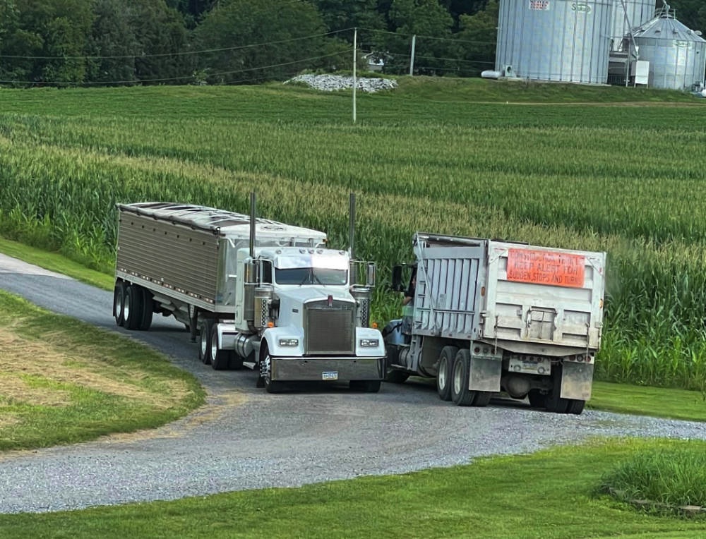 Two American trucks passing on the driveway to the family farm.