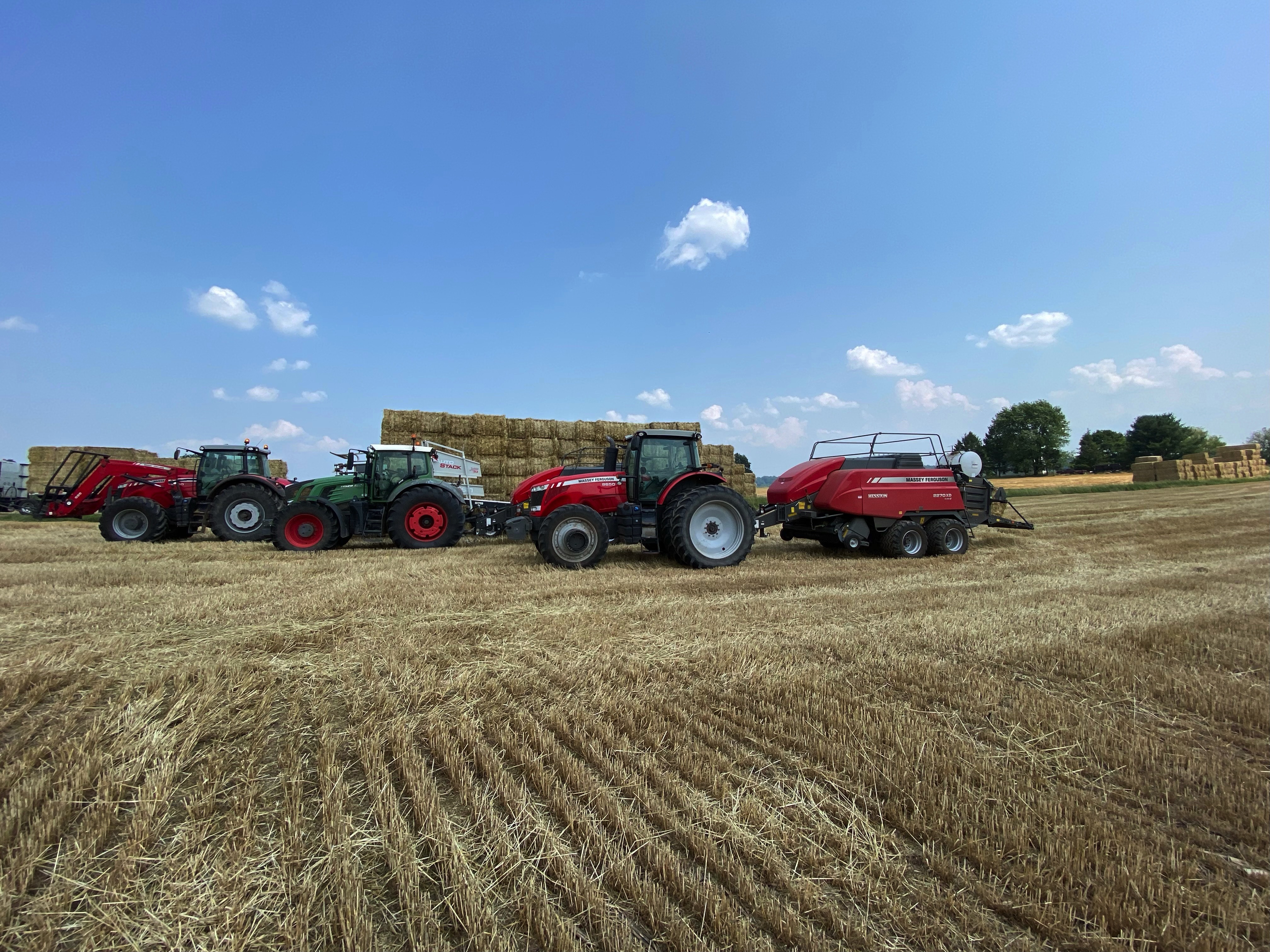 Farm tractors and bailers out working the field