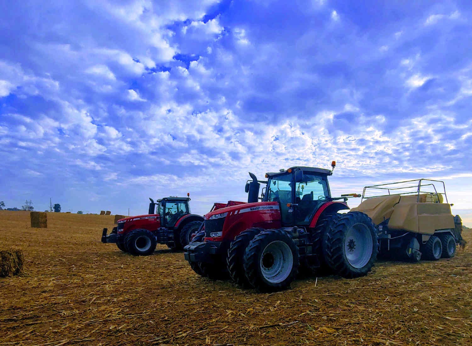 Tractors making large bails on the family farm.